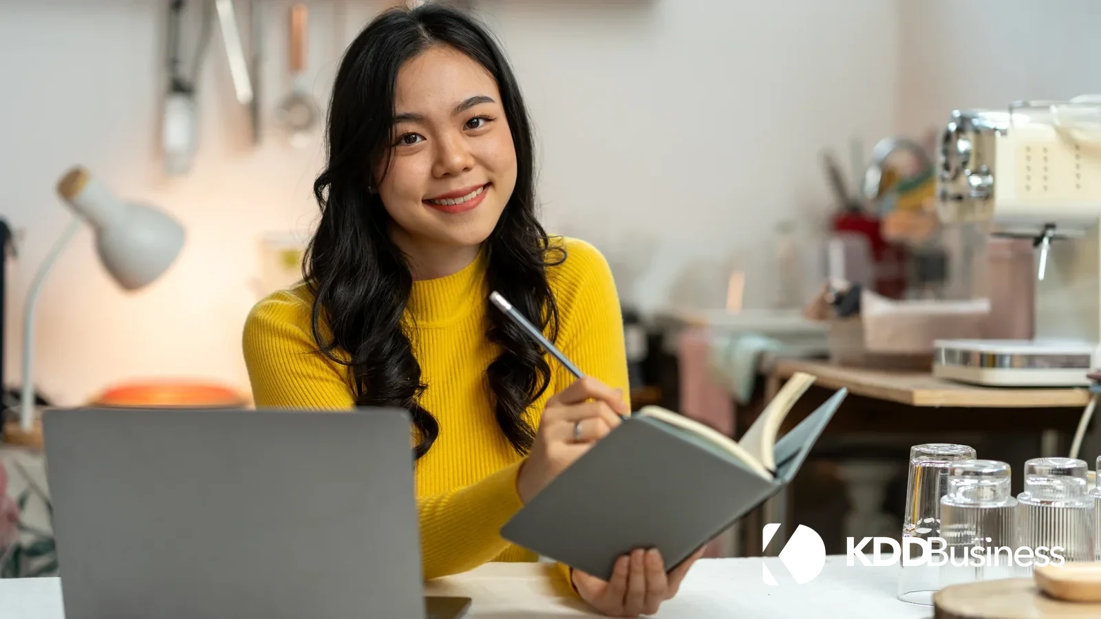 Emprender sin dejar tu trabajo: persona trabajando en su negocio propio desde casa con portátil y agenda